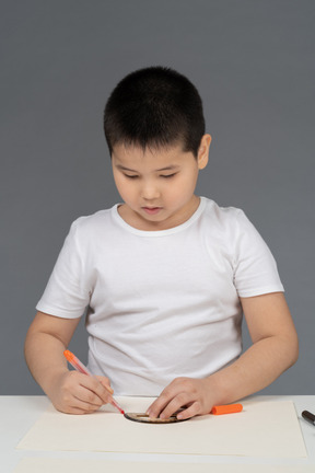 Asian boy drawing geometric shapes using ruler
