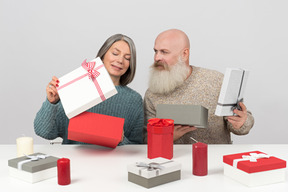 Elegante casal de idosos descompactar presentes de natal