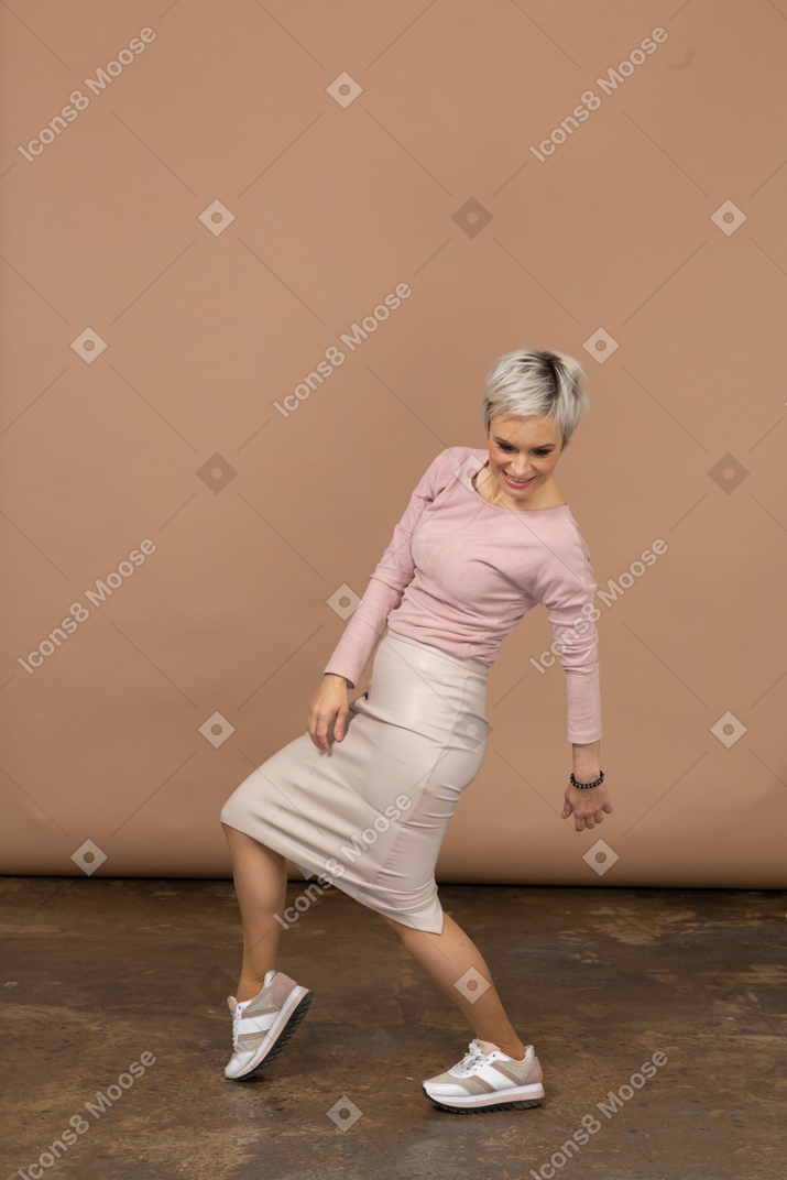 Vista lateral de uma mulher com roupas casuais curvando-se para trás e olhando para baixo