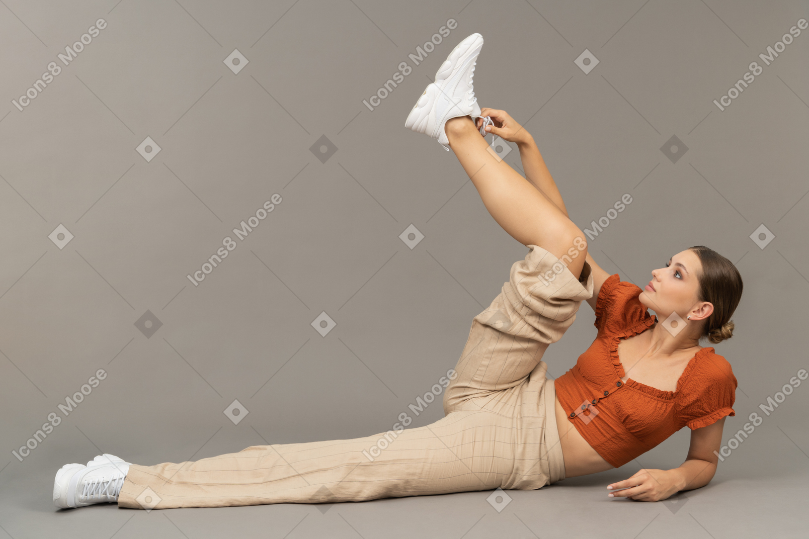Young woman lies down with her leg up