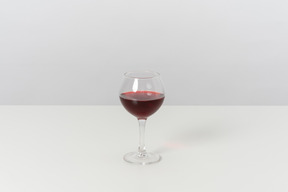 Glass of red wine on grey background