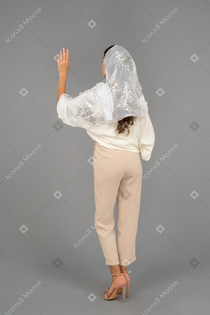 Unrecognizable brunette woman waving with a hand