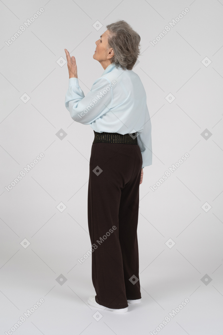 Вид сбоку на пожилую женщину, вопросительно жестикулирующую вверх