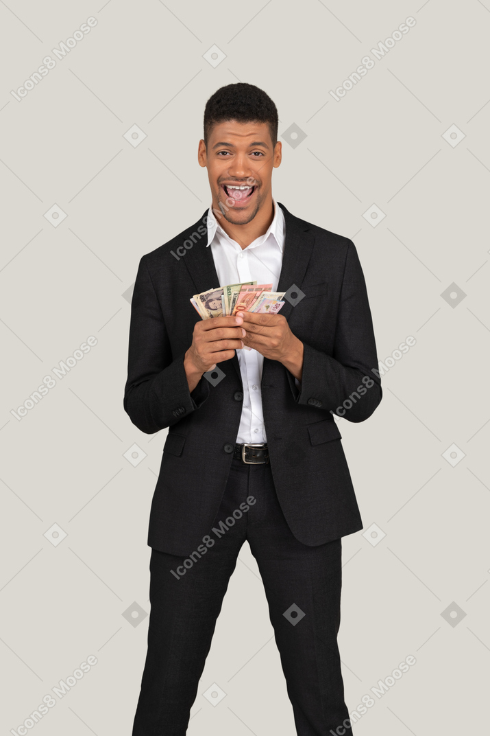 Three-quarter view of a young man in black suit holding banknotes