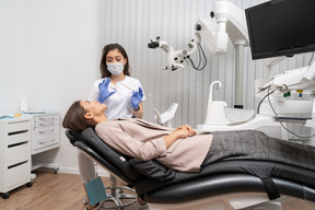 Full-length of a female dentist consulting her female patient in a hospital cabinet