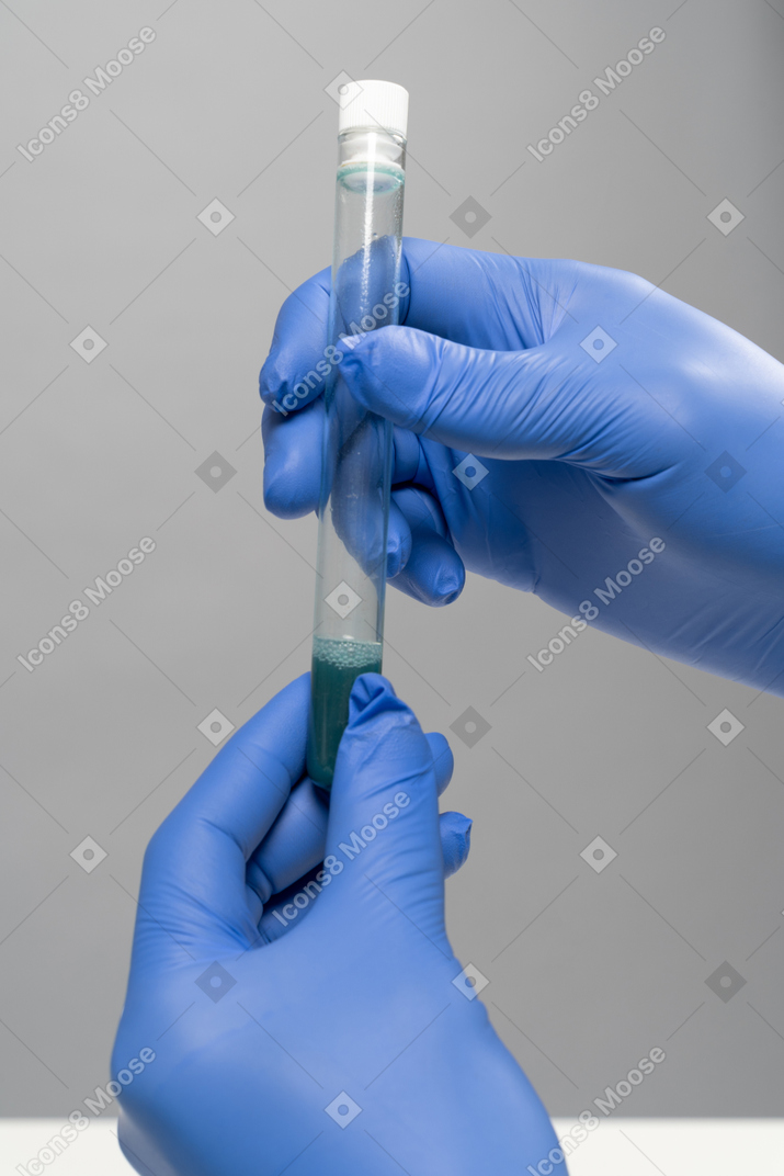 Hands in gloves holding medical tube