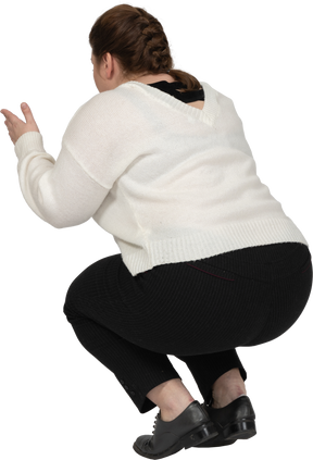 Vista posteriore di una donna plus size in abiti casual accovacciata