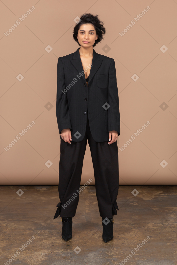 Front view of a smirking businesswoman in a black suit looking at camera