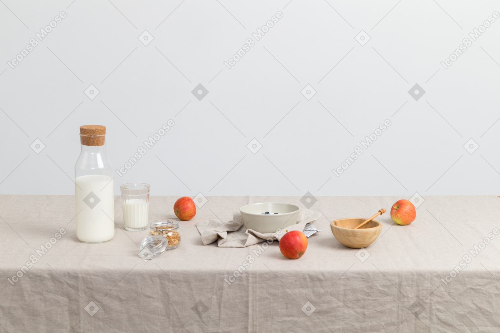 Bottle of milk, glass og milk, red apples and bowls