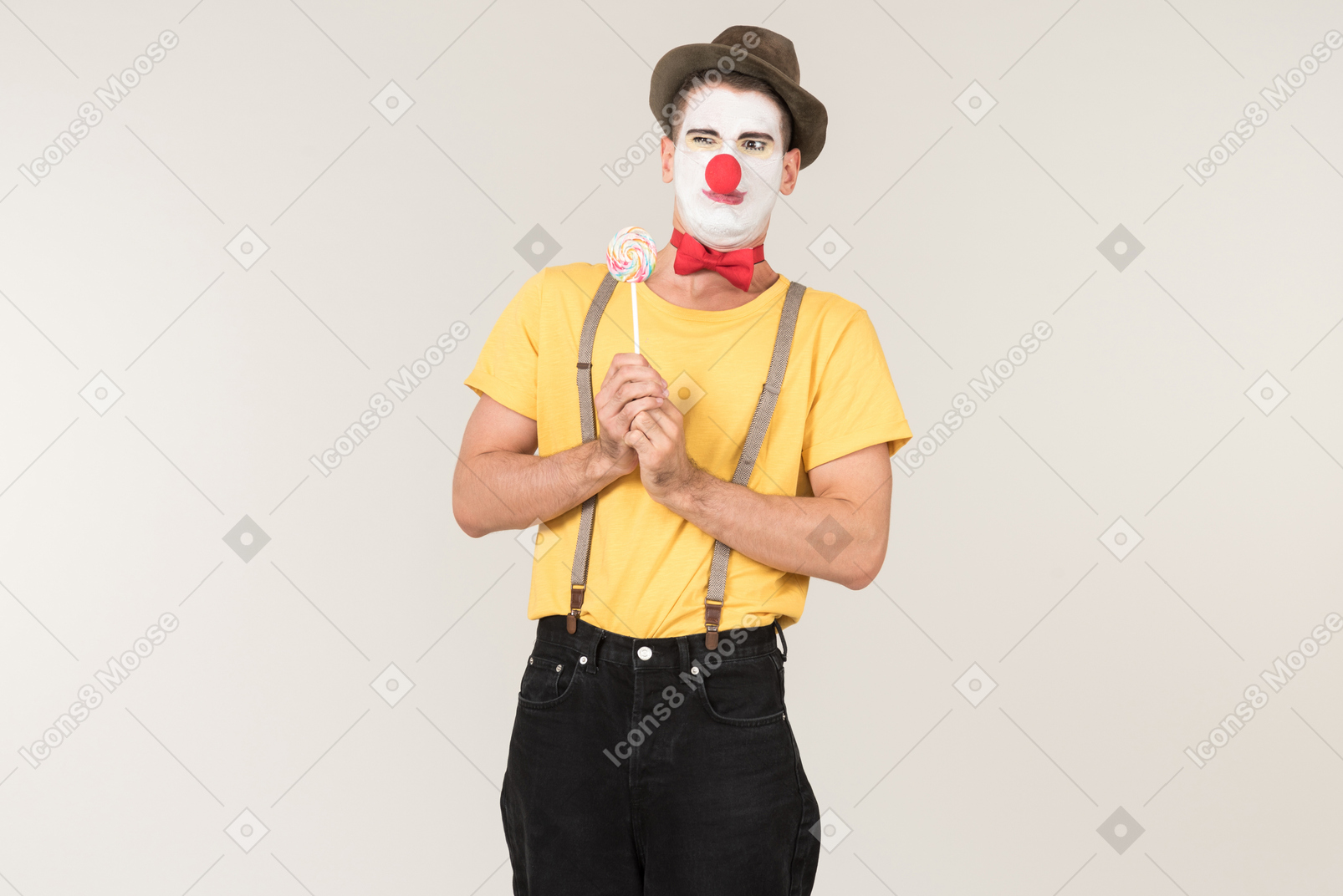 Disgusted male clown holding lollipop