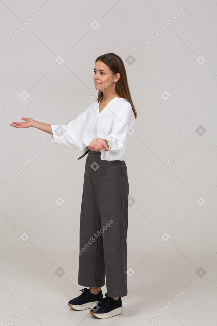 Three-quarter view of a young lady in office clothing outspreading hands