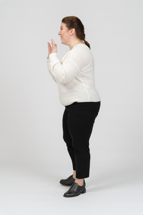 Surprised plump woman in casual clothes standing in profile