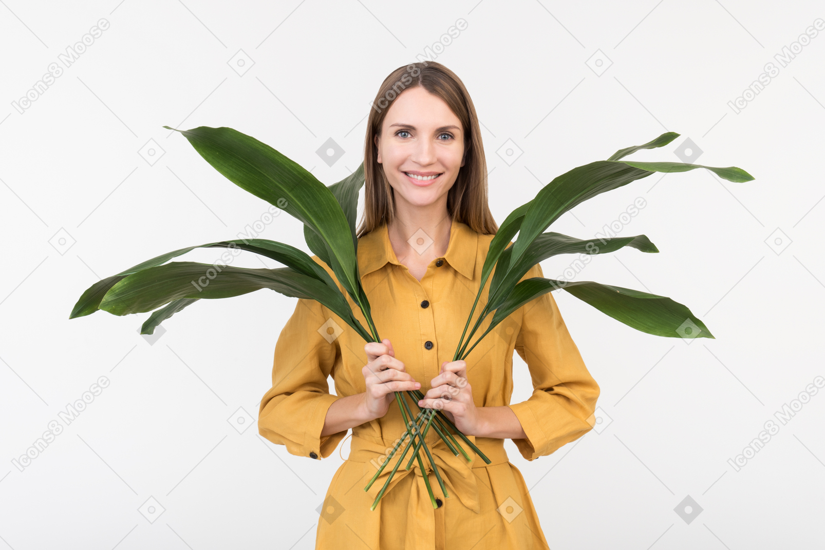 Smiling young woman holding green leaves in both hands