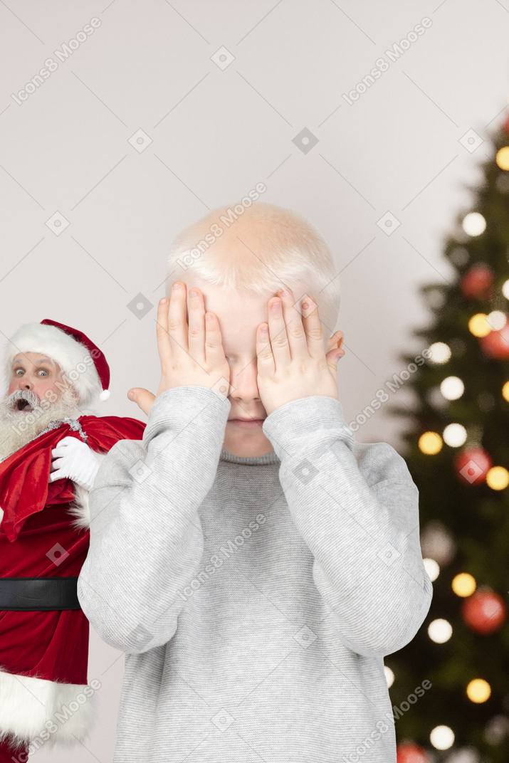 Little boy and santa are playing hide-and-seek