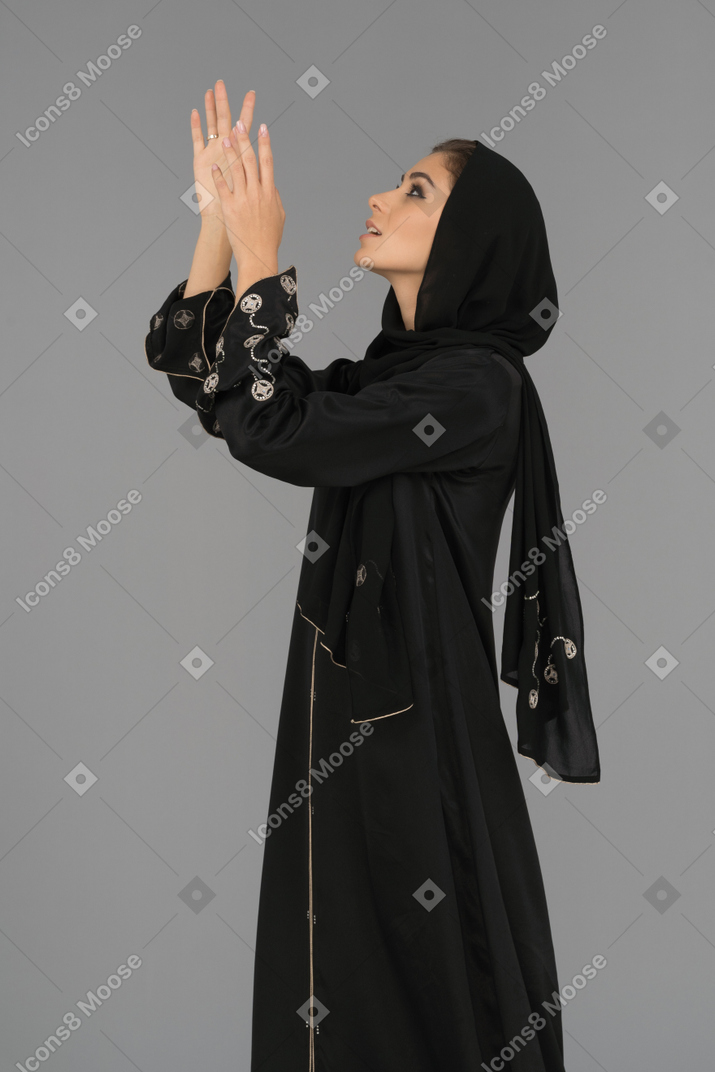 Muslim woman pointing upwards