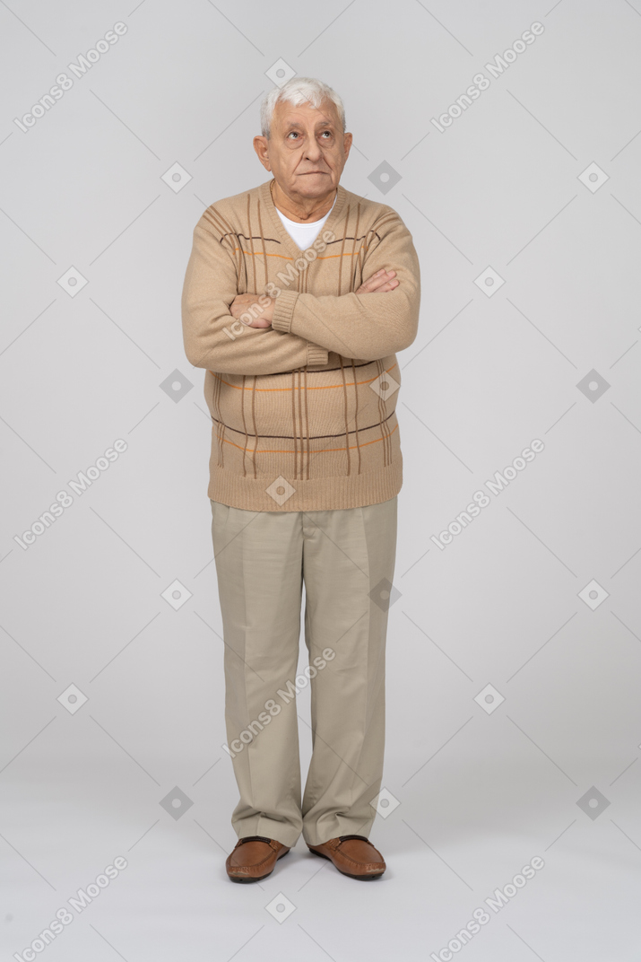 Vorderansicht eines alten mannes in freizeitkleidung, der mit verschränkten armen steht