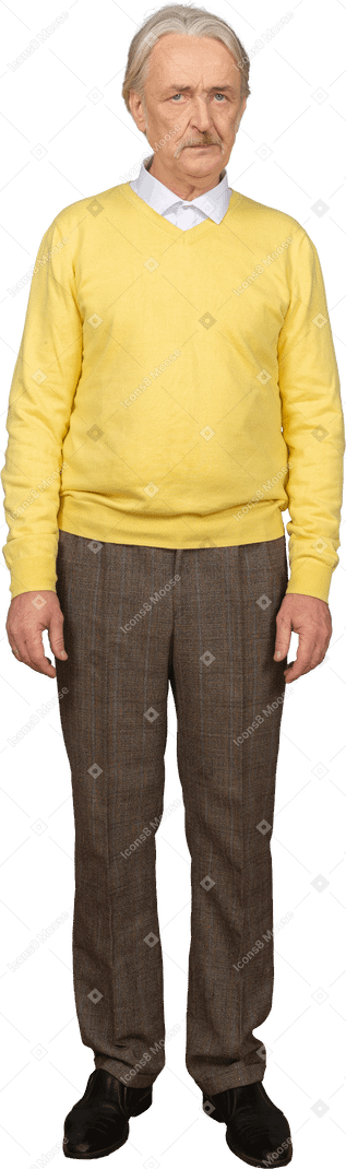 Vista frontal de um velho descontente vestindo um pulôver amarelo e olhando para a câmera