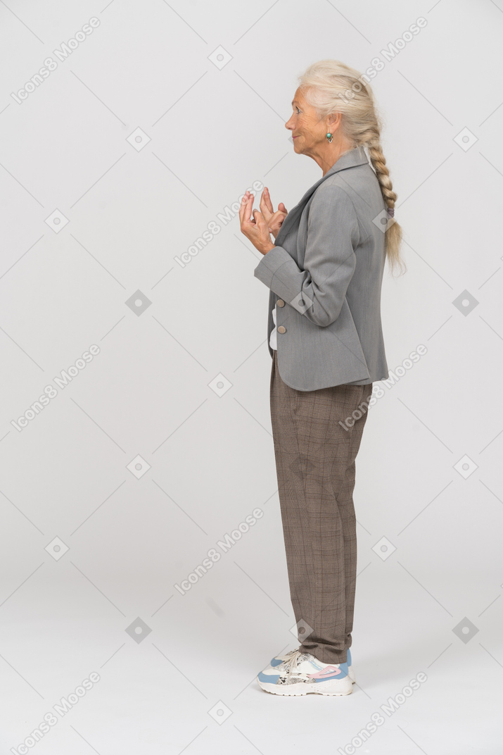 Side view of an old lady in suit pointing up with fingers