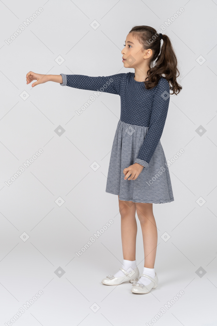 Vue de trois quarts d'une jeune fille tendant la main