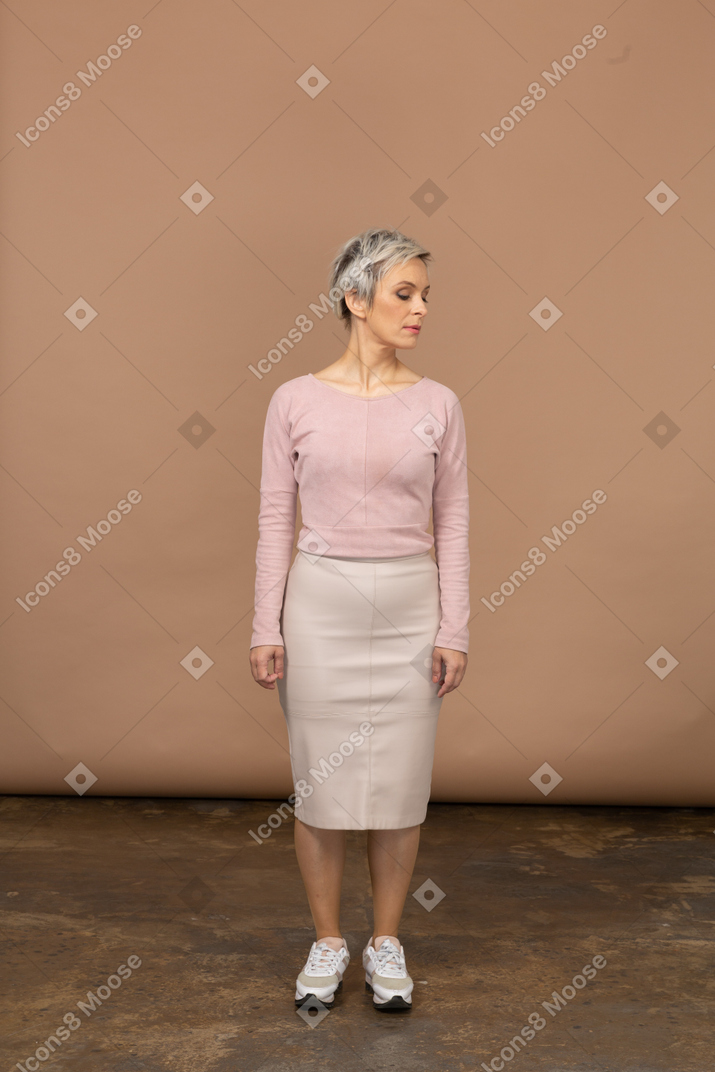 Vista frontal de uma mulher pensativa em roupas casuais olhando para baixo