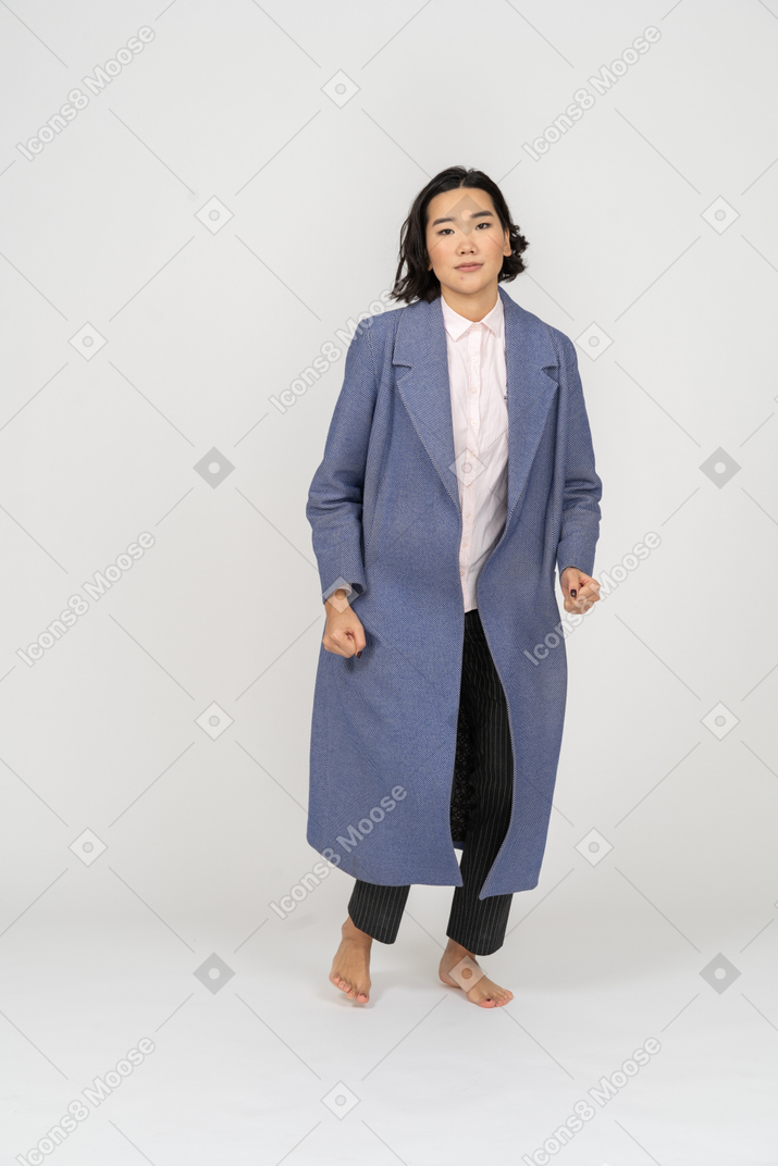 Woman in coat on bent legs