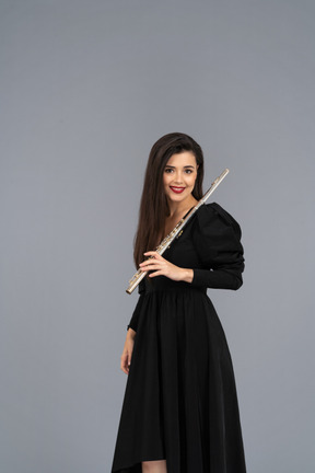 Front view of a smiling young lady in black dress holding flute