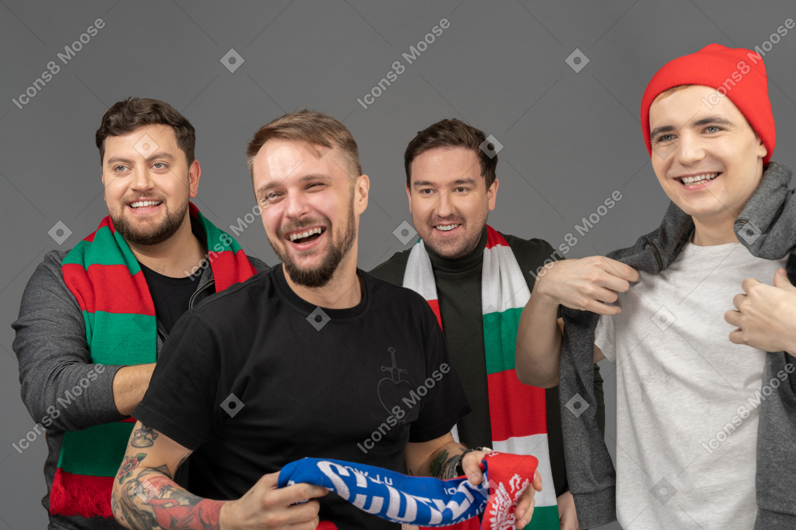 Крупный план четырех улыбающихся футбольных фанатов мужского пола, смотрящих в сторону