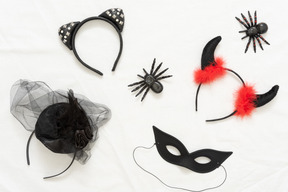 Different halloween headbands, toy spiders and a black mask