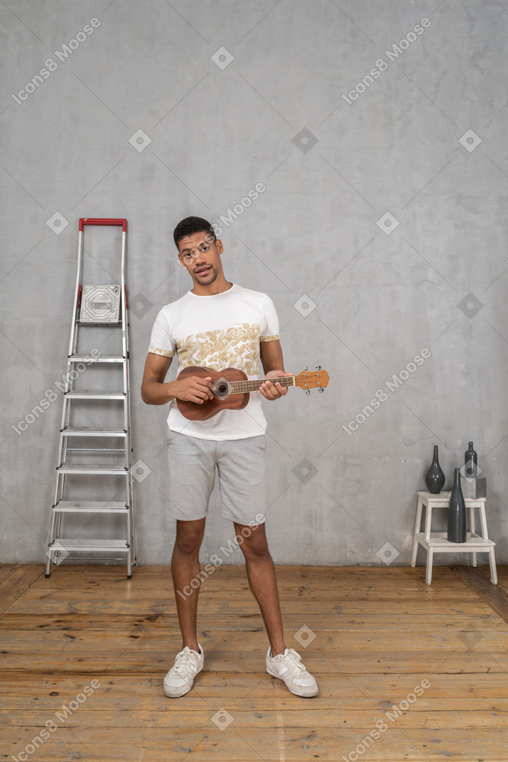 Vue de face d'un homme jouant du ukulélé
