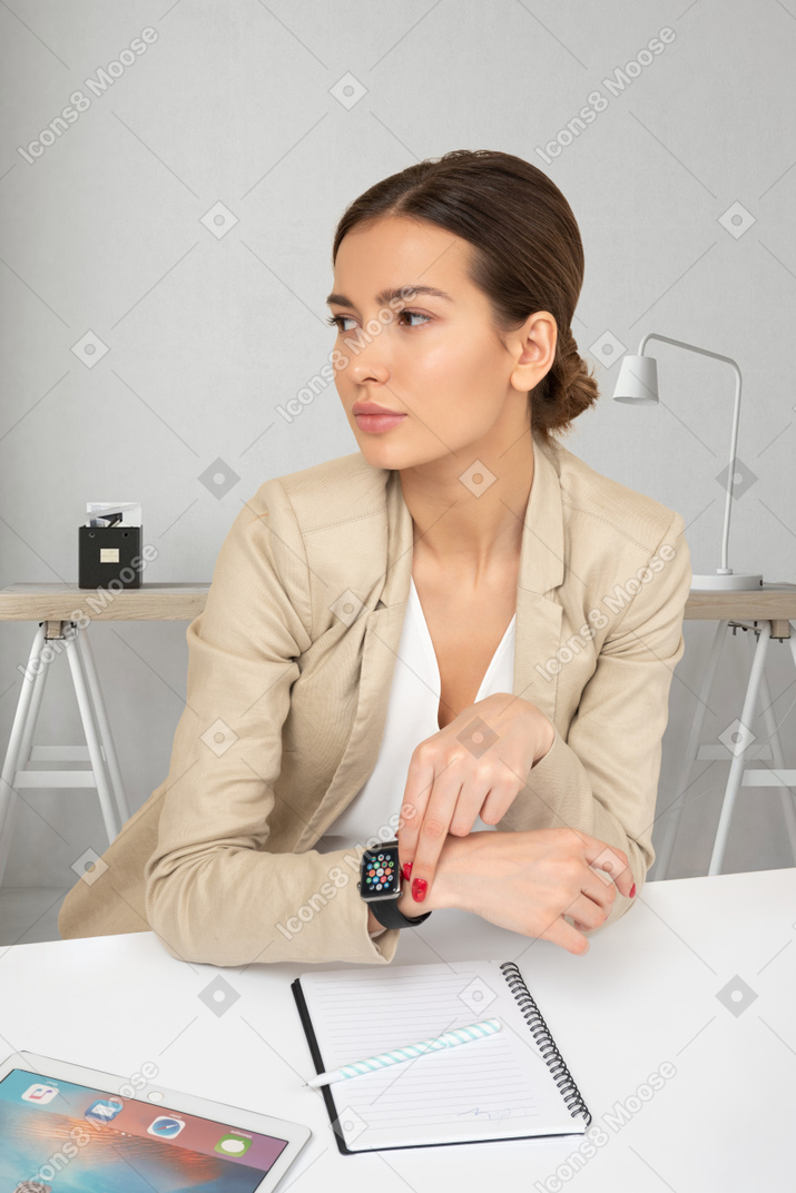 A woman sitting at a table with an apple watch