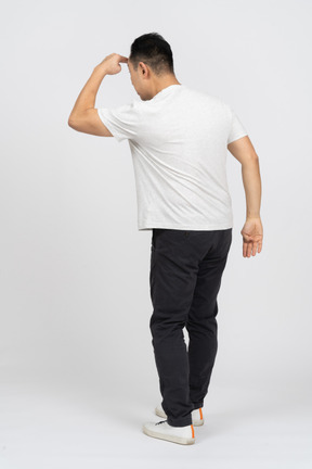 Rear view of a man in casual clothes looking for someone