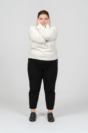 Front view of a plump woman touching face
