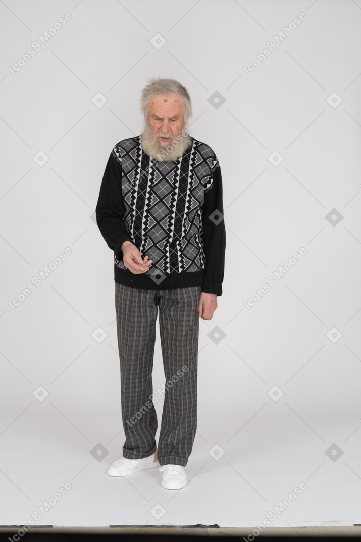 Vista frontale di un uomo anziano in abiti casual che guarda in basso