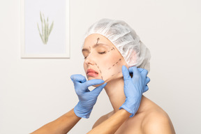 手術の準備をしている顔のマーキングを持つ若い女性