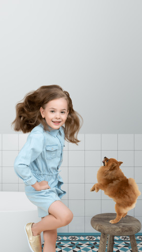 Little girl jumping next to dog