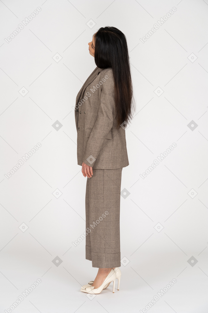 Side view of a young lady in brown business suit tilting head