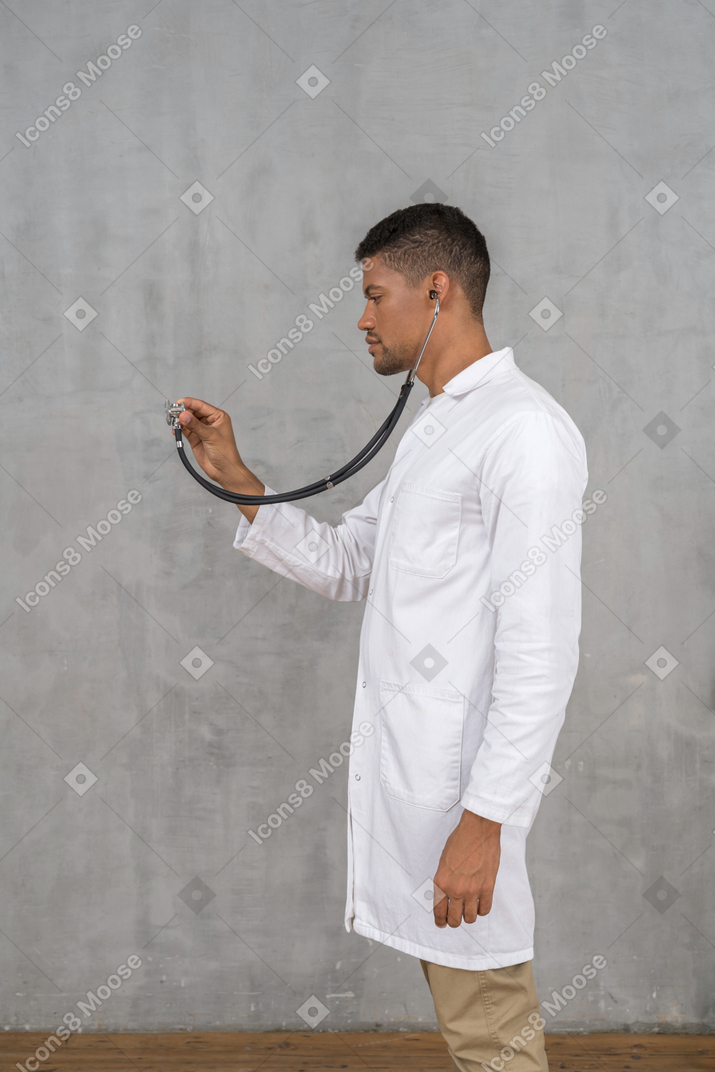 Side view of a male doctor using a stethoscope