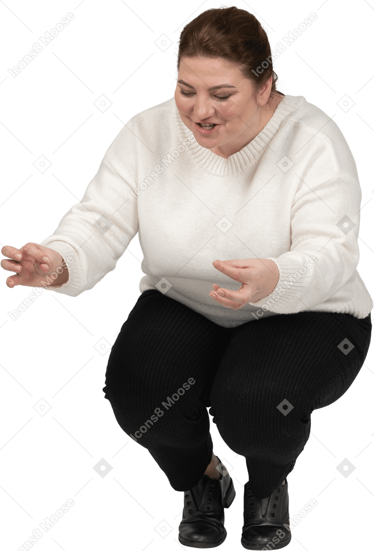 Вид спереди счастливой пухлой женщины в повседневной одежде, сидящей на корточках