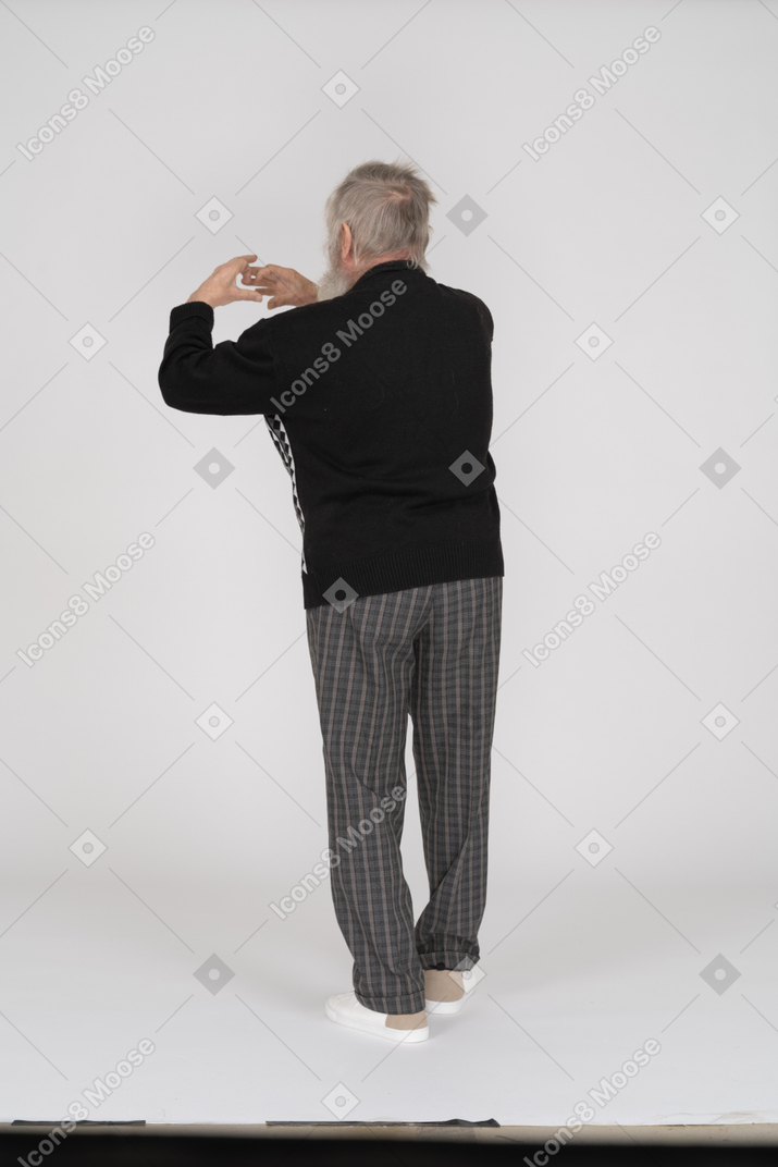 Rear view of old man gesturing with two arms