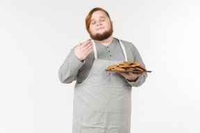 Um homem gordo apreciando o cheiro de biscoitos