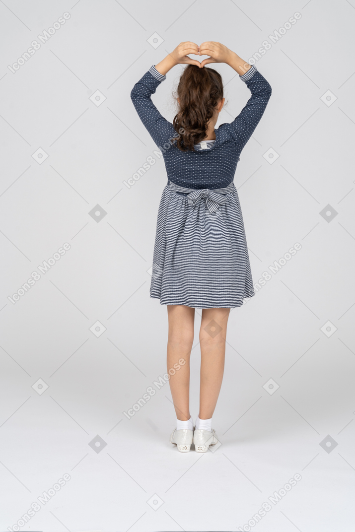 Back view of a girl making a heart with her hands above her head