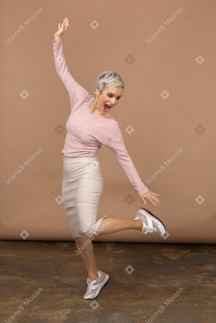 一个穿着休闲服跳跃的女人的前视图