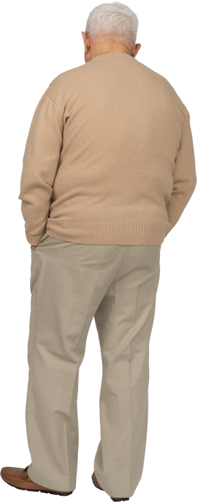 Вид сзади на старика в повседневной одежде, стоящего с руками в карманах