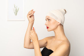 Side view of a young woman holding syringe