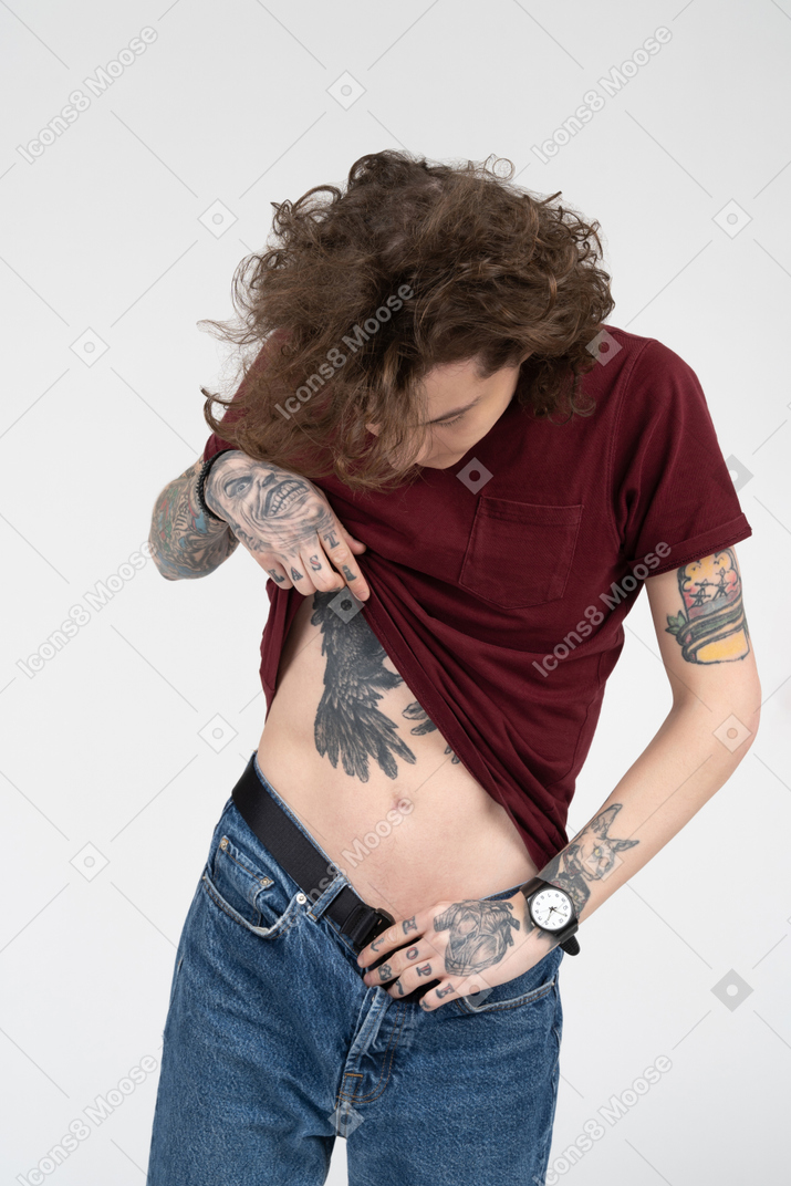 Tattooed teenager examining his body