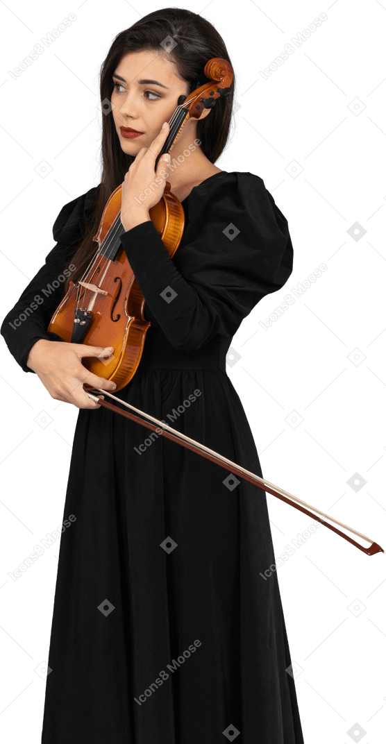 Close-up de uma jovem de vestido preto segurando o violino