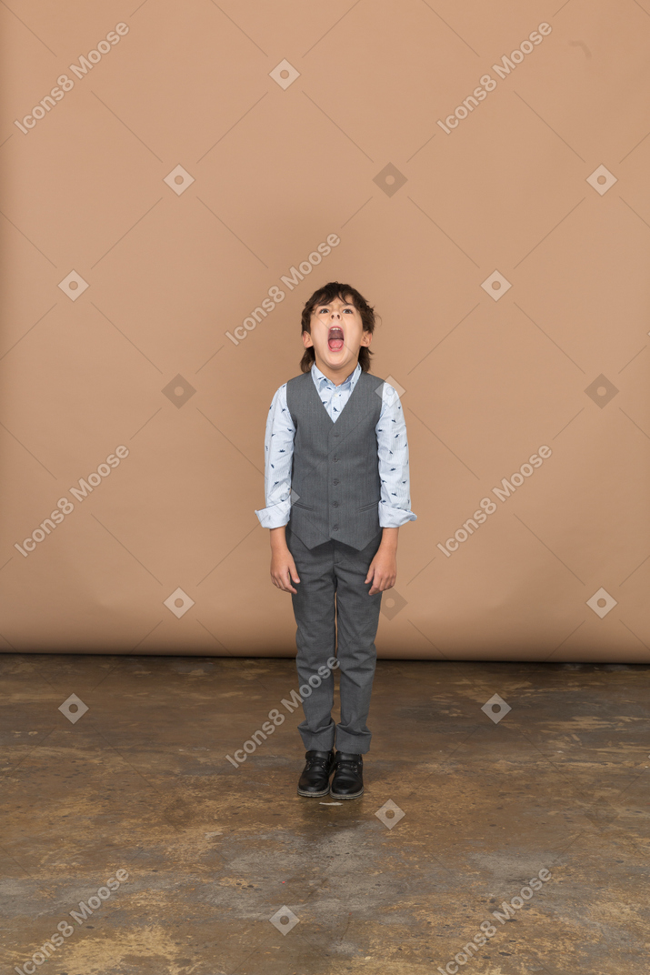 Vista frontale di un ragazzo in giacca e cravatta che guarda in alto