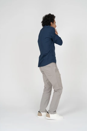 Side view of a man in casual clothes hugging himself