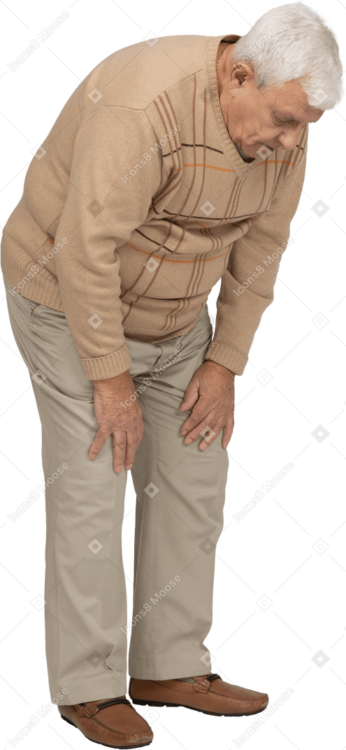 Vue latérale d'un vieil homme en vêtements décontractés se penchant et touchant son genou blessé
