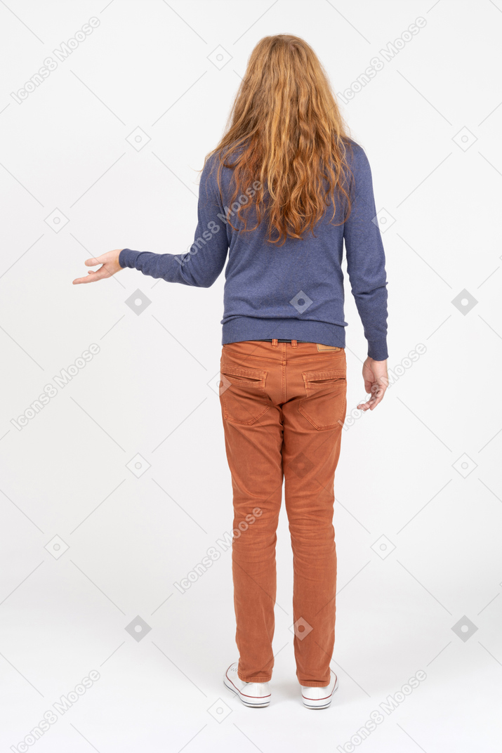 Rear view of a young man in casual clothes doing invitation welcome gesture